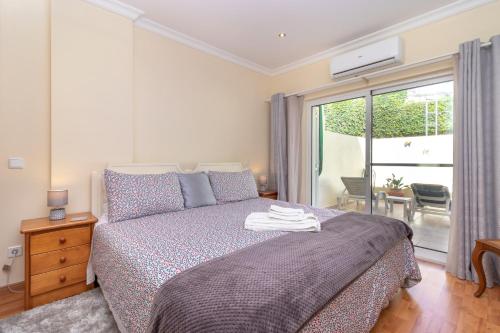 a bedroom with a bed and a sliding glass door at Casa Amiga in Praia do Carvoeiro
