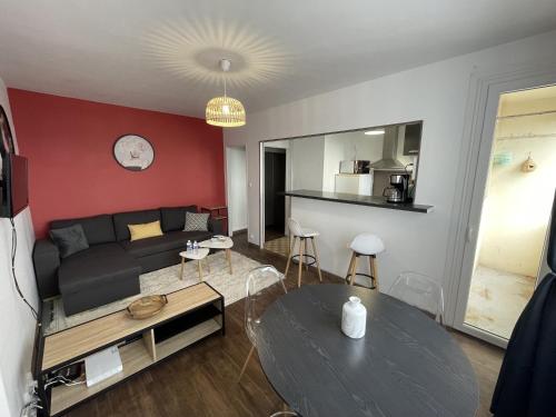 un salon avec un canapé et une table dans l'établissement Tegmen, Joli appartement au calme, à Caen