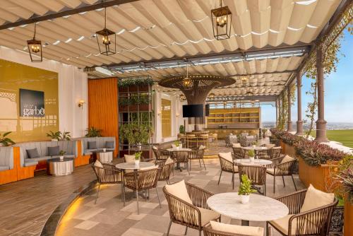 an outdoor patio with tables and chairs and a restaurant at Meliá Vinpearl Phu Ly in Phủ Lý