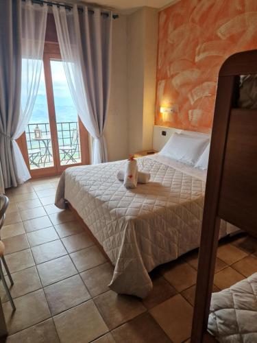 ein Schlafzimmer mit einem Bett und einem großen Fenster in der Unterkunft Hotel La Rocca in San Marino