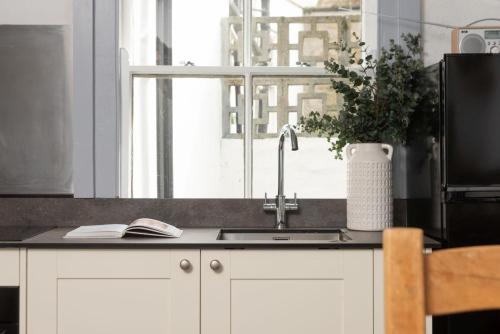 a kitchen counter with a sink and a window at Saffron Cottage, St Ives in St Ives