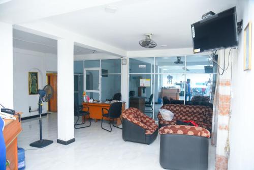 Hotel Prasanna في ترينكومالي: غرفة معيشة مع كنبتين ومكتب