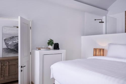 a white bedroom with a white bed and a white bed sqor at White Sand Suites Mykonos in Mikonos