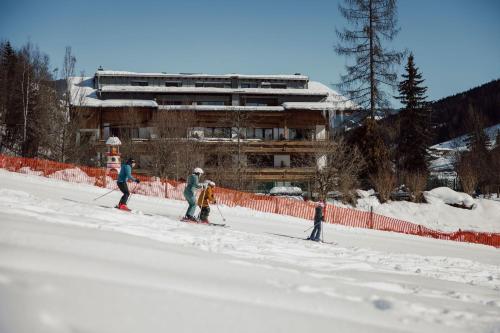 a group of people on skis in the snow at Familien- & Gartenhotel Theresia 4-Sterne Superior in Saalbach Hinterglemm