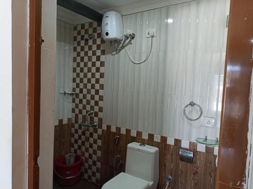 ein kleines Bad mit einem WC und einer Dusche in der Unterkunft Coco homes by myroom in Candolim