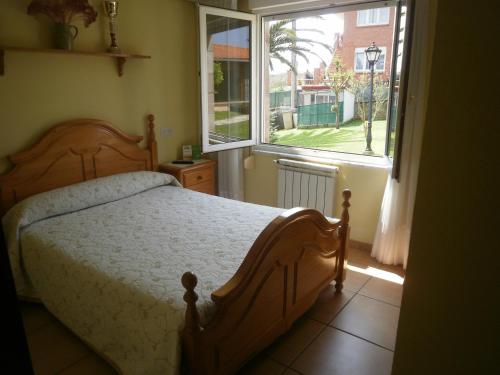a bedroom with a bed and a large window at Pensión Galimar in San Vicente de la Barquera
