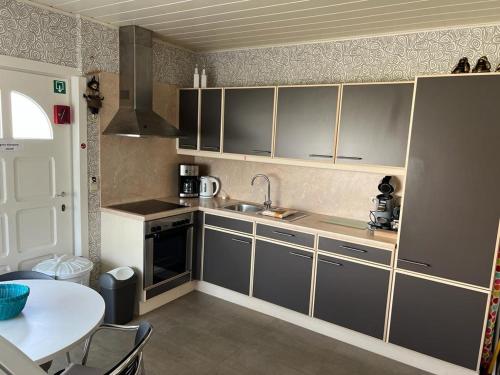 a small kitchen with a sink and a table at Huize Liesanne in Bredene