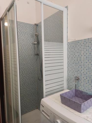 W łazience znajduje się prysznic i fioletowa umywalka. w obiekcie Love and Peace House con deposito biciclette privato w mieście Finale Ligure