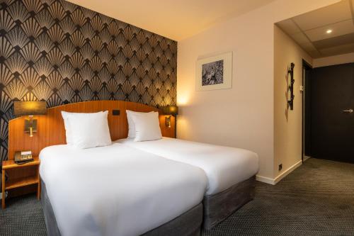 a bedroom with a large white bed in a room at Aris Grand Place Hotel in Brussels