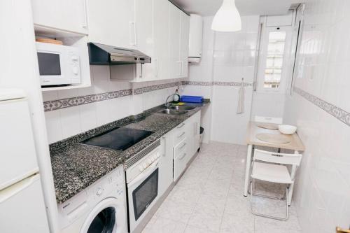 2 Bedroom Apartment Lloret de Mar Terrace & Pool في يوريت دي مار: مطبخ أبيض مع حوض وغسالة صحون