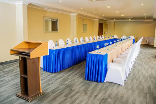 une salle de conférence avec des tables et des chaises bleues et blanches dans l'établissement CBD Hotel, à Dar es Salaam