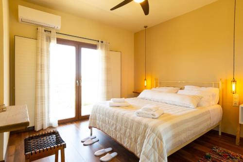 a bedroom with a large bed and a large window at Istron Agnanti in Agios Nikolaos