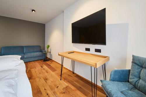 a room with a bed and a table and a tv at Hotel Reiler Hof in Reil