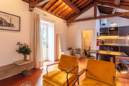 a kitchen and living room with a table and chairs at Pico do Refúgio - Casas de Campo in Ribeira Grande