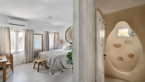 Un dormitorio con una cama y una mesa en una habitación. en Villa Mykonos Heaven - Sea View & Outdoor Hot Tub, en Mykonos ciudad