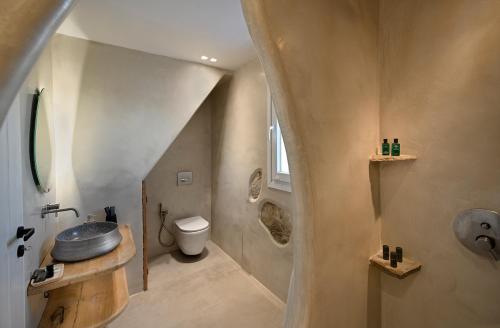 een kleine badkamer met een wastafel en een toilet bij Villa Mykonos Heaven - Sea View & Outdoor Hot Tub in Mykonos-stad