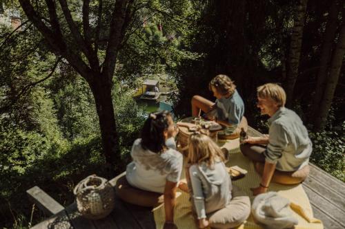 un grupo de personas sentadas alrededor de una mesa de picnic en Gartenhotel Theresia 4-Sterne Superior en Saalbach Hinterglemm