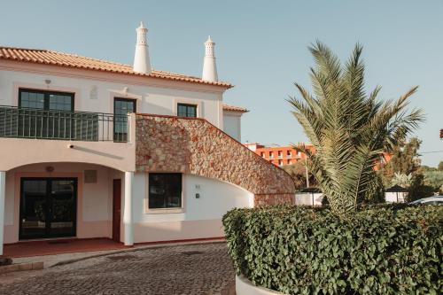 a house with a palm tree in front of it at Casa Velha Apartments - Adults friendly in Albufeira