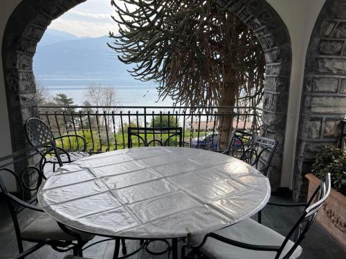 a table and chairs on a balcony with a view of the ocean at Villa Niccolò in Griante Cadenabbia