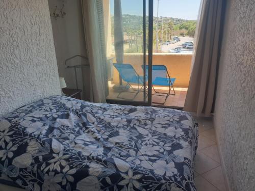 sypialnia z łóżkiem i widokiem na balkon w obiekcie 3 pièces face mer et St-Tropez w mieście Cogolin