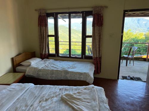 1 dormitorio con 2 camas y ventana grande en Astam Resort, en Astam