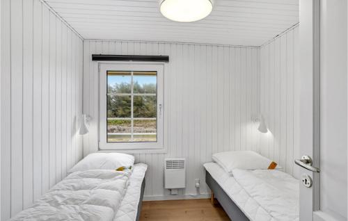 two beds in a white room with a window at 2 Bedroom Stunning Home In Harbore in Harboør