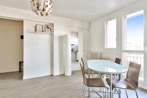 een eetkamer met een witte tafel en stoelen bij Charming flat with balcony at the doors of Paris - Welkeys in La Courneuve