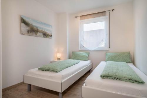 2 Betten in einem kleinen Zimmer mit Fenster in der Unterkunft Star - Vogelhaus in Friedrichshafen