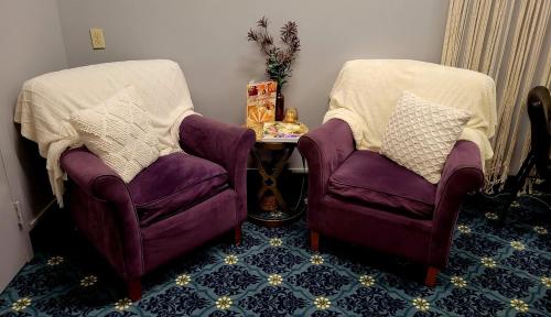 two purple chairs and a table in a room at Bangor Grande Hotel in Bangor
