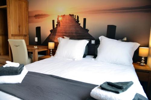 a bedroom with a bed with white sheets and a pier at Guest House Aan de Hollandse IJssel in Montfoort