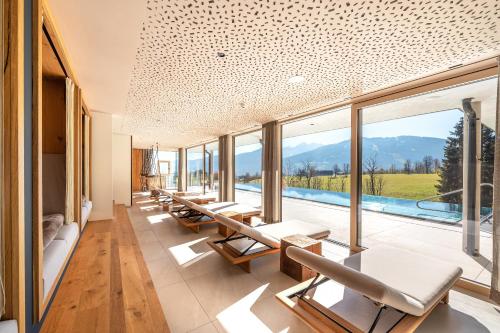 een kamer met tafels en stoelen en een zwembad bij Hotel Ennstalerhof in Ramsau am Dachstein