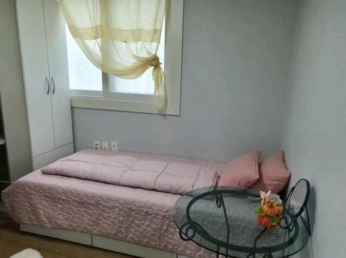 um quarto com uma mesa de vidro e uma janela em Cozy Place near Kyeongbuk university em Daegu