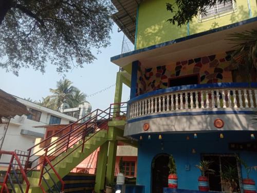 a colorful building with a staircase next to a building at Advait Holiday Home in Nagaon