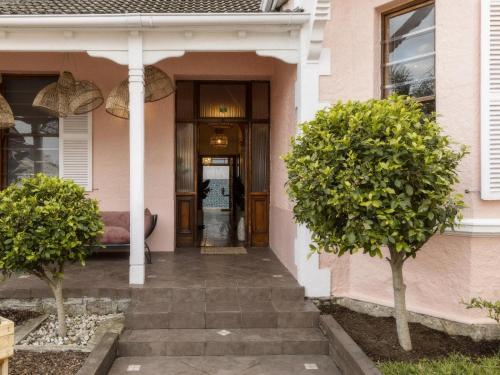 a front door of a pink house with two trees at Sweet Orange Guest House in Cape Town
