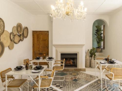 comedor con 2 mesas y chimenea en Sweet Orange Guest House, en Ciudad del Cabo