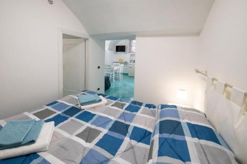 um quarto com uma cama azul e branca num quarto em Divina Casa Vacanze em Sperlonga