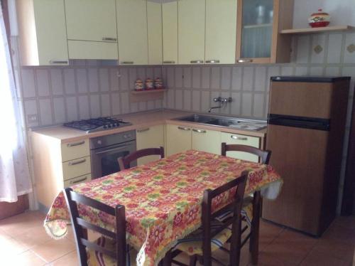 a kitchen with a table and chairs and a kitchen with a stove at Casa Alessandra in Pomonte