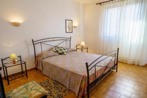 une chambre avec un lit et deux tables de chevet dans l'établissement La Caletta Corsa Apartments - 2 Camere, Terrazza Privata a 100m dal Mare, WiFi Fibra, à Linguizzetta