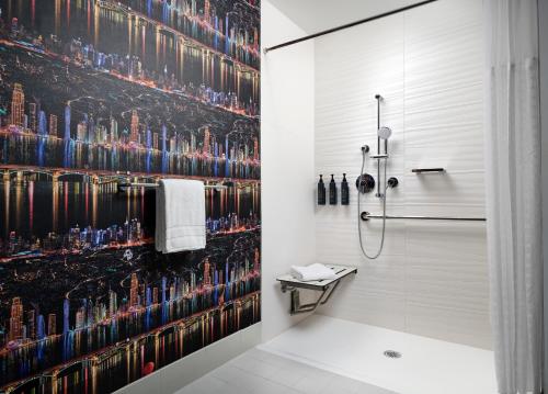 a bathroom with a shower with a wall of alcohol bottles at Aloft Henderson in Las Vegas