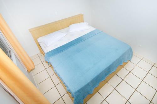 - un petit lit avec une couverture bleue dans l'établissement Residencial Primavera, à Bombinhas