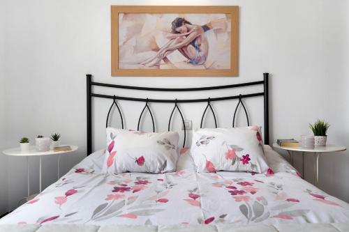 a bed with two pillows and a picture on the wall at Apartamento Acogedor in Puerto del Carmen