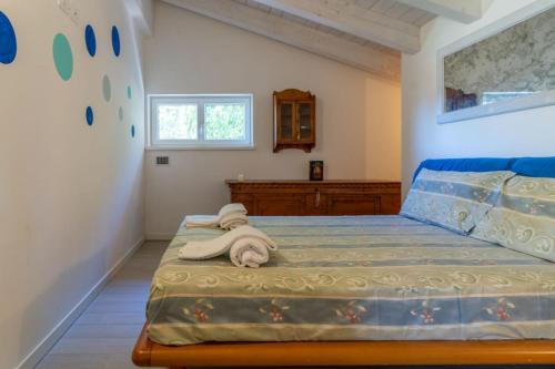 a bedroom with a bed with a towel on it at Alle Coccinelle, Levico Terme Ospitar in Levico Terme