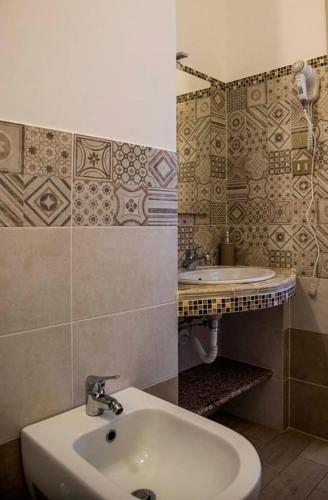 a bathroom with a sink and a toilet and a mirror at Blu Mare Lampedusa Bed And Breakfast in Lampedusa
