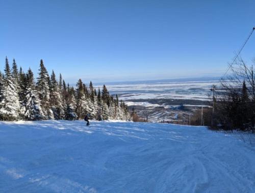 a person is skiing down a snow covered slope at Habitations Zenith in Sainte-Anne-de-Beaupré