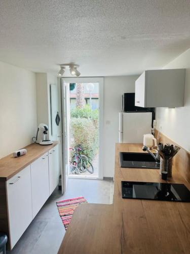 a kitchen with white cabinets and a wooden counter top at La maison du Clos in Valras-Plage