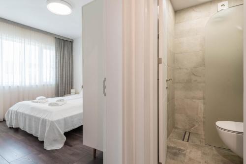 a bedroom with a bed and a bathroom with a shower at Cosy apartment in central Varna in Varna City
