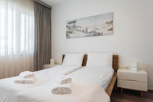 two twin beds in a bedroom with white walls at Cosy apartment in central Varna in Varna City