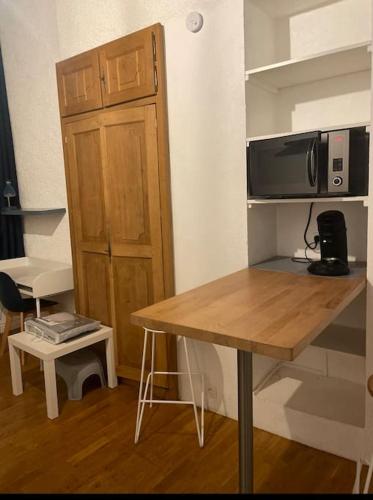 Cette petite chambre comprend une table et un four micro-ondes. dans l'établissement Studio vieille ville, à Besançon