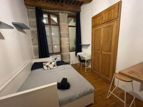 um quarto com uma cama, uma secretária e uma janela em Studio vieille ville em Besançon