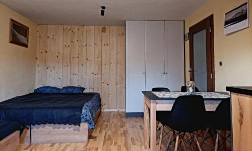 a bedroom with a bed and a table with chairs at Górska Przygoda in Koniaków